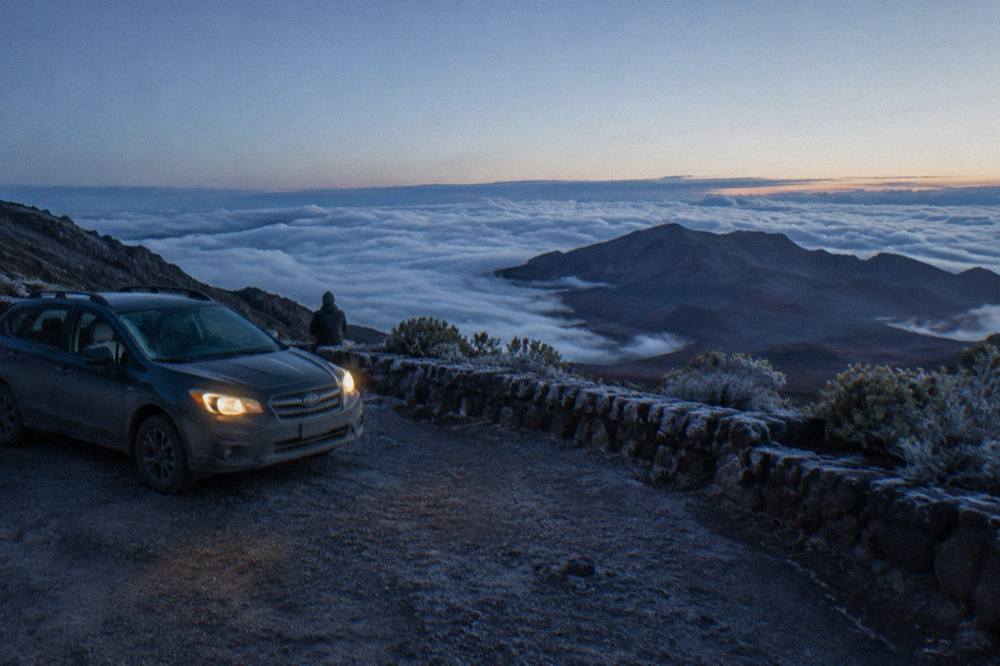 A quiet summit overlook parking area above a sea of clouds at dawn on Haleakala