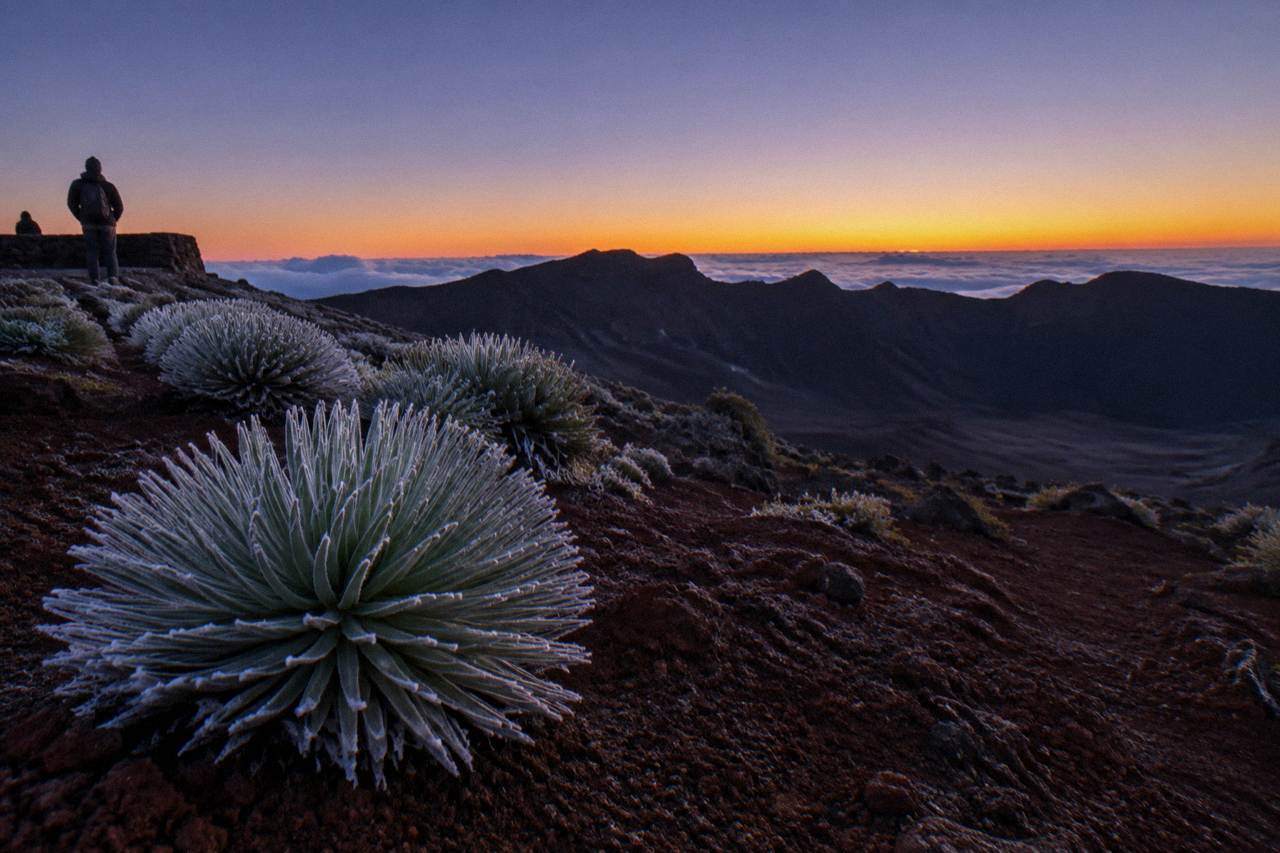 Silhouetted crater rim with sunrise glow over Haleakala summit