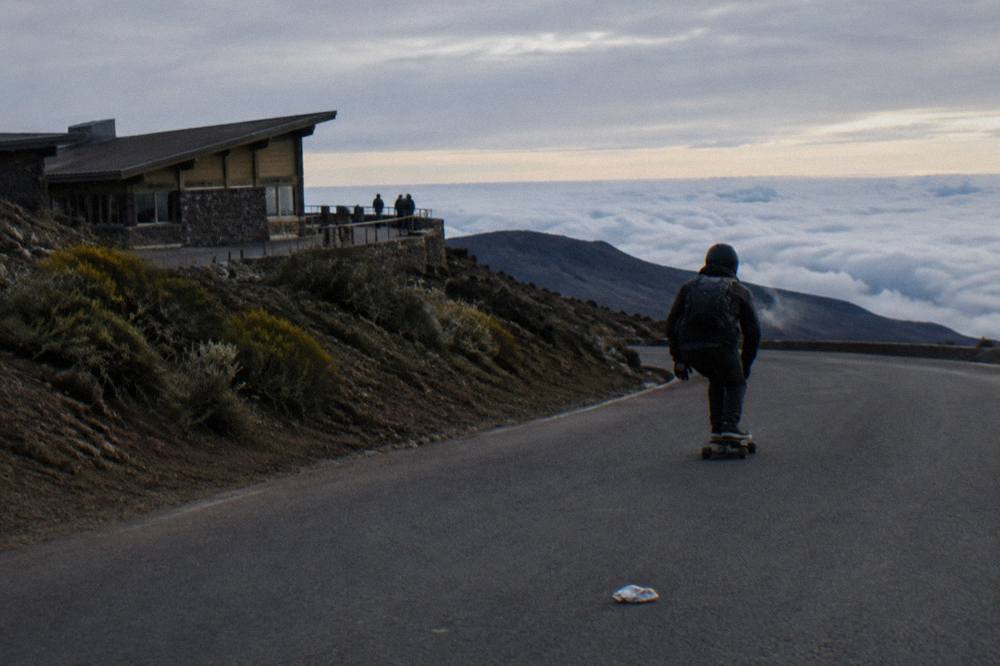 A bicyclist coasting along the shoulderless crater road above the clouds on Maui