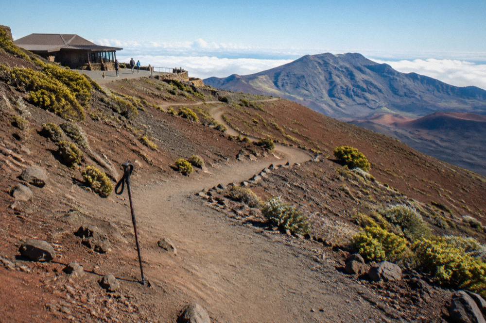Sandy trail descending from a crater rim into colored cinder slopes
