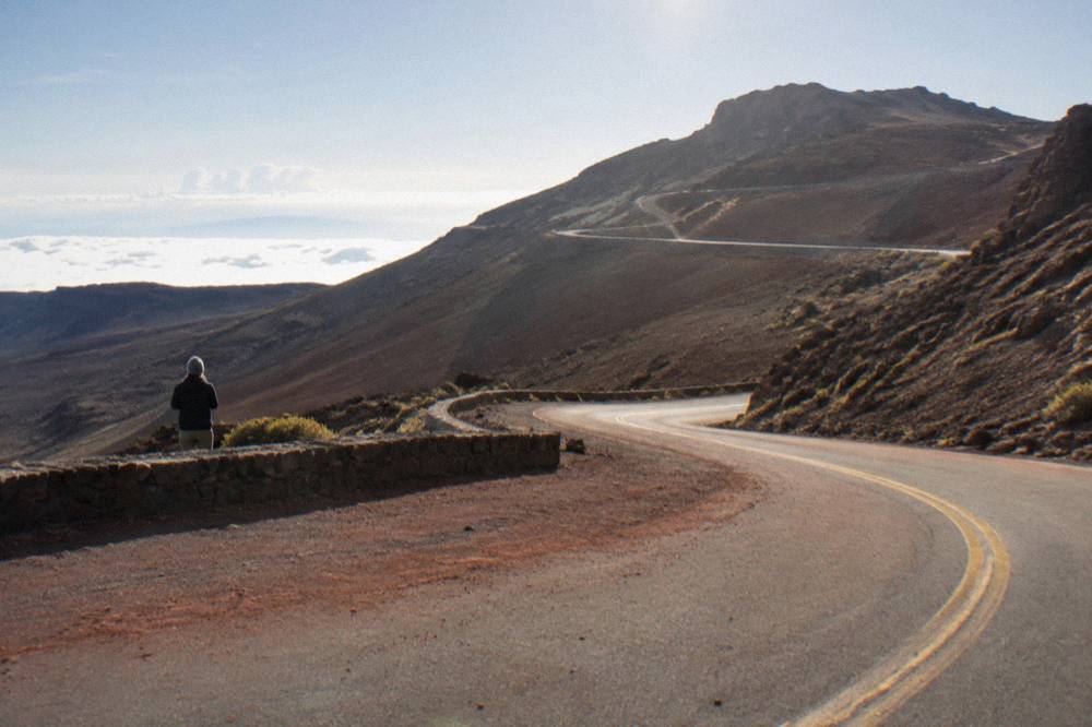 Steep mountain road with sharp hairpin curves cut into barren volcanic slopes