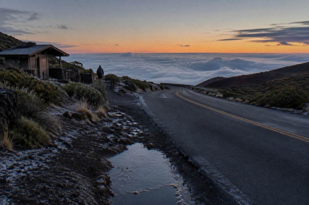 Quiet mountain road at dusk above a sea of clouds on Haleakala