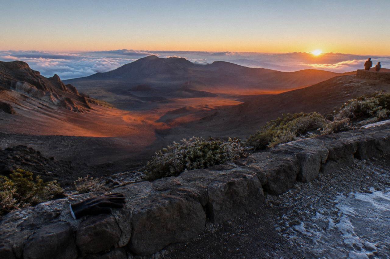 Dawn light spreading across the Haleakala crater floor seen from a summit overlook