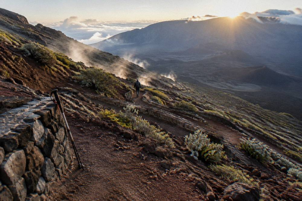 A switchbacking trail descending through red cinder toward the crater floor