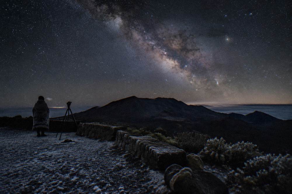 A star-filled night sky above the silhouetted Haleakala summit