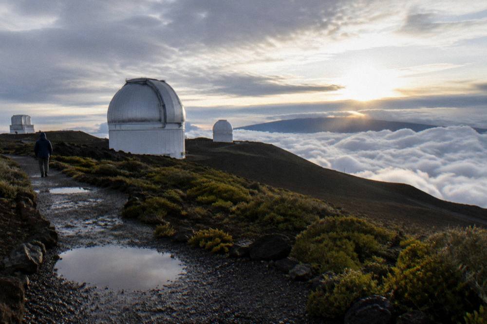 Early morning light breaking over clouds below the crater rim