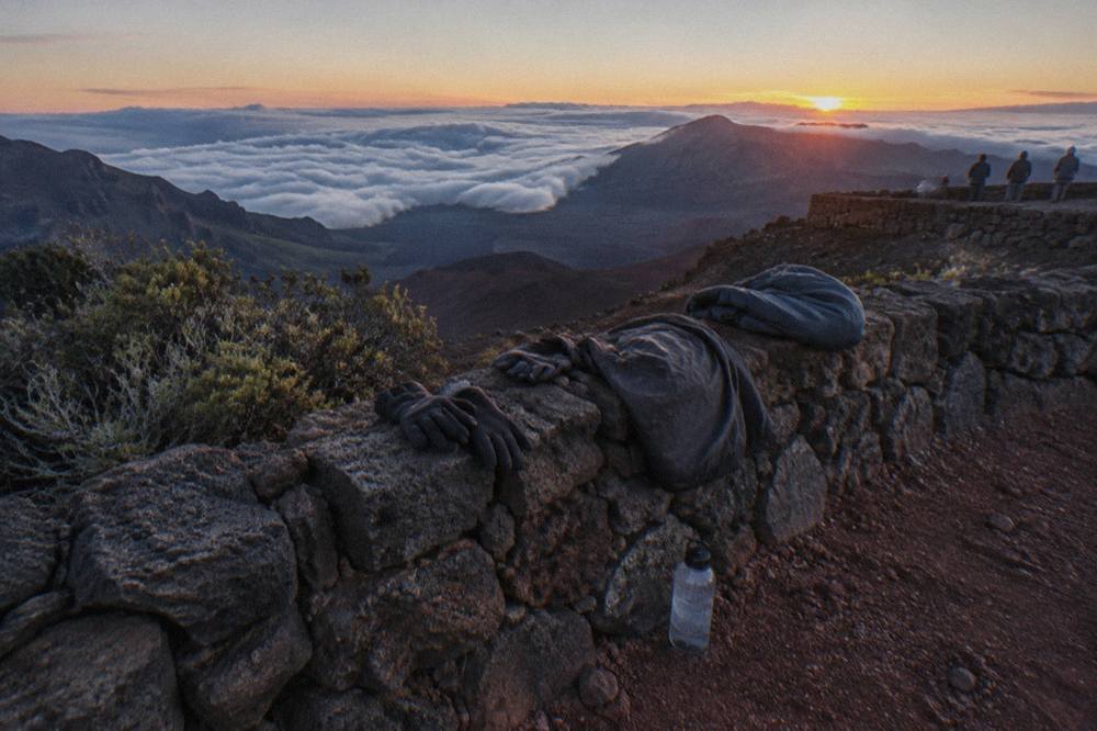 Bicycles parked beside a volcanic crater overlook above a sea of clouds