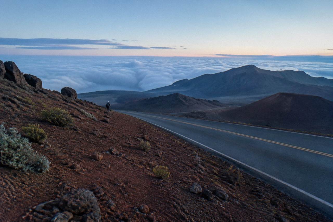 Winding crater road descending through open volcanic slopes at dawn