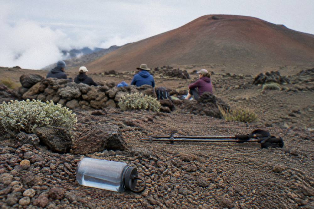 A small group of hikers resting beside cinder cones on the crater floor