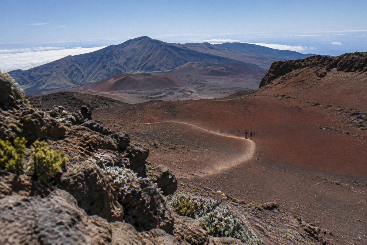 A winding trail crossing the red cinder landscape inside the Haleakala crater