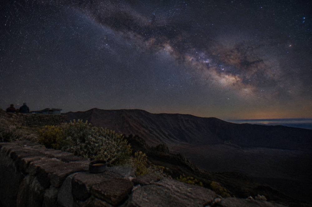 The Milky Way visible over the dark ridge of the Haleakala crater at night