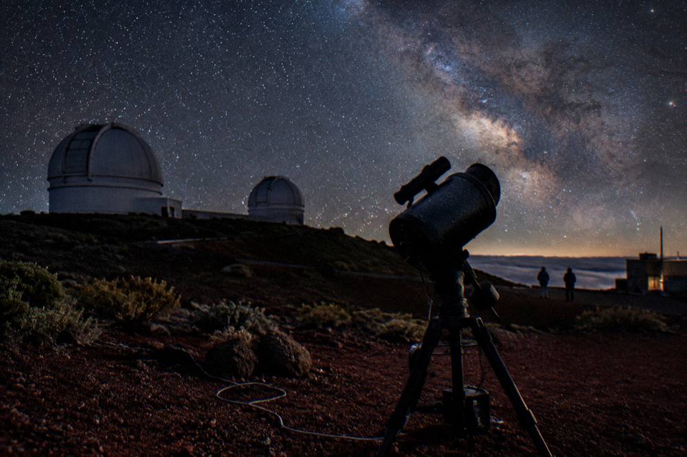 A telescope silhouette against a star-filled sky above the Haleakala summit