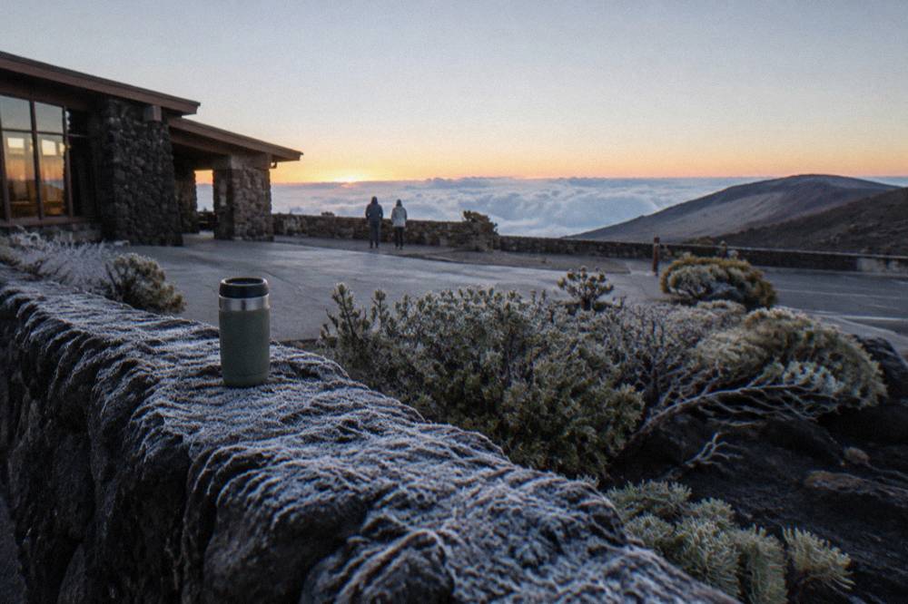 The Haleakala summit overlook at dawn with frost on the rocks and a pale horizon