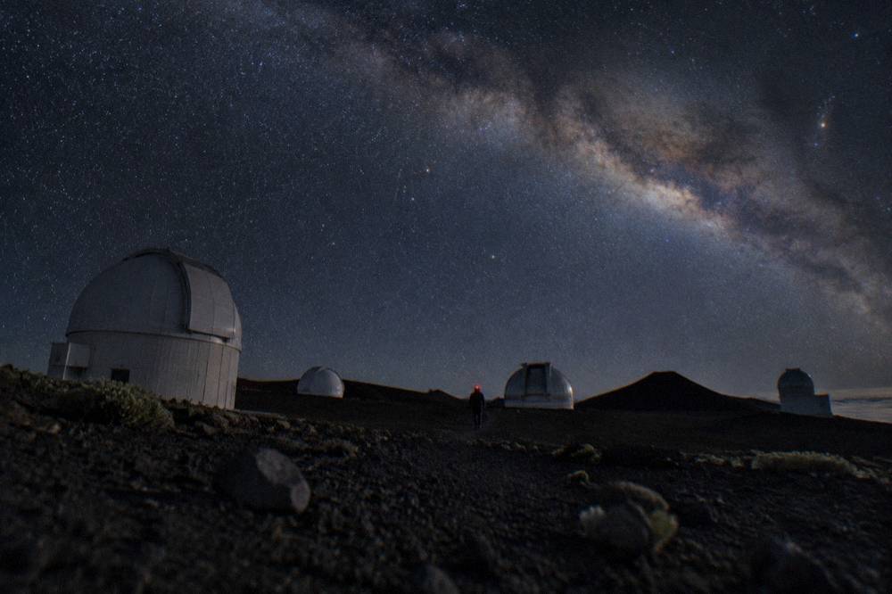 The Milky Way arching over the dark silhouette of the Haleakala summit cinder cones