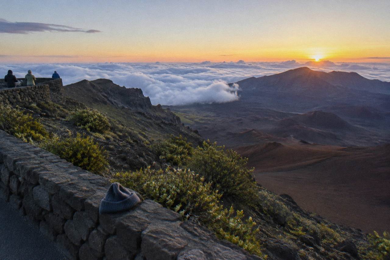 Dawn light breaking over the ridges of the Haleakala crater above a sea of clouds