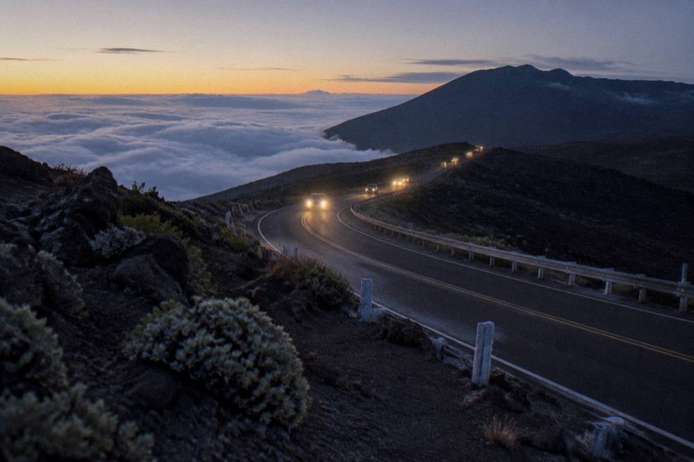 A line of headlights climbing the switchback road toward the Haleakala summit before dawn