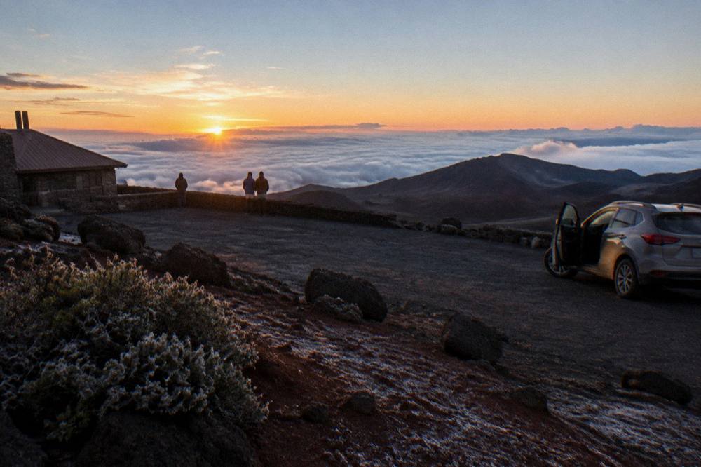The sun clearing the horizon above a cloud layer as seen from the Haleakala summit