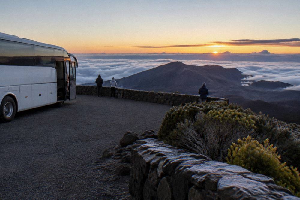 A coach parked at a summit overlook above the clouds at dawn