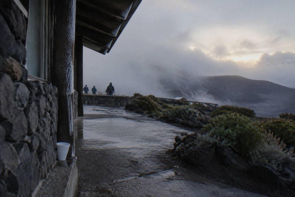 The small stone visitor center building on the crater rim at first light