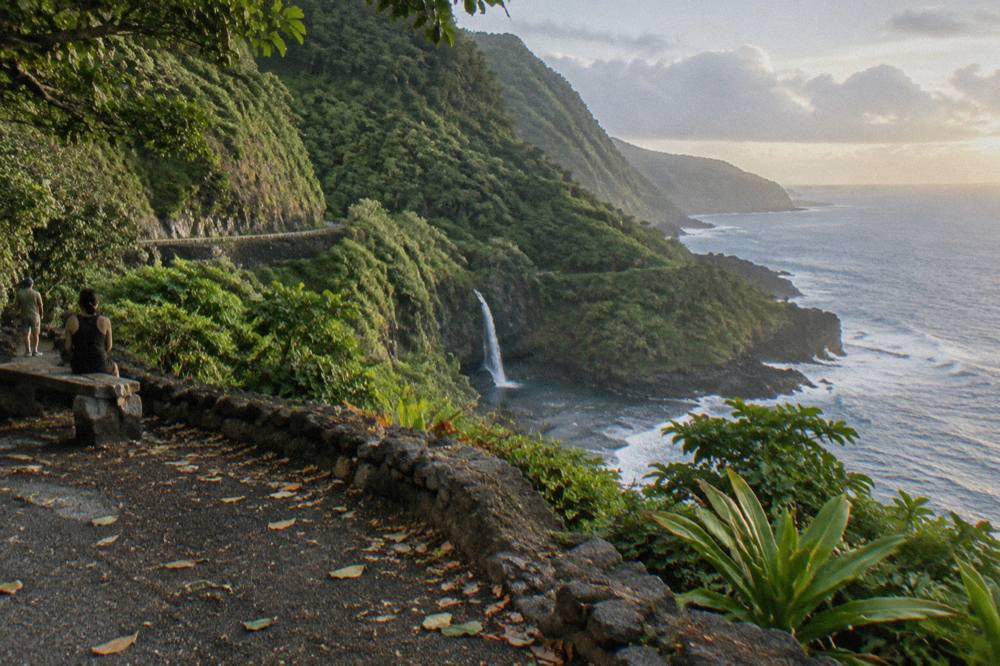A winding coastal road along green cliffs above the ocean