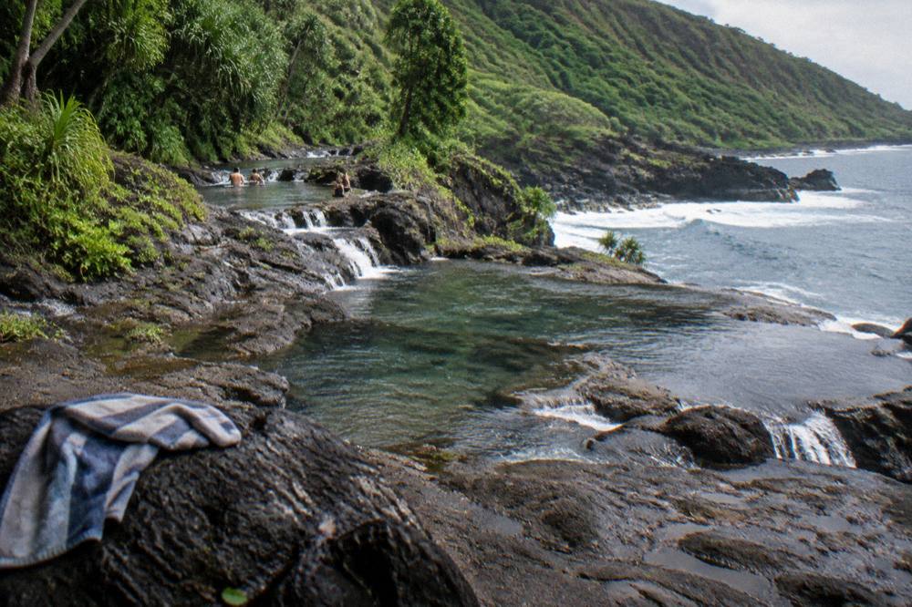 A rocky stream bed with terraced pools dropping toward the ocean