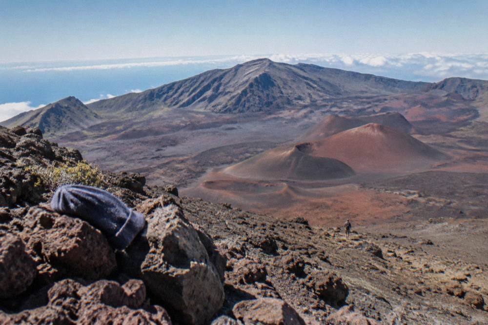 A volcanic crater floor stretching below a high ridge under a wide sky