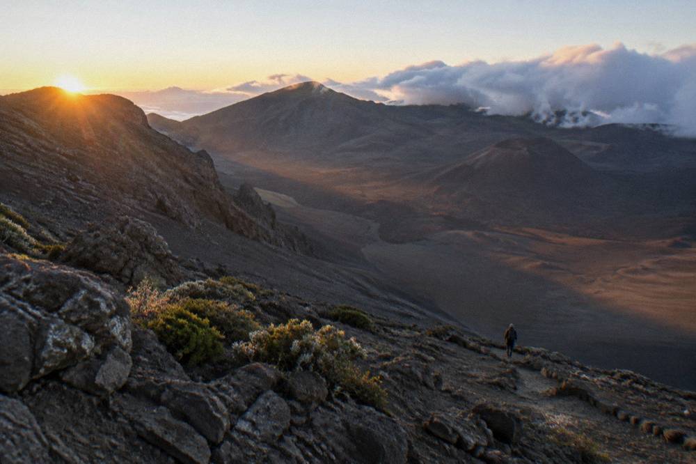 Early light on a volcanic crater floor with long shadows across cinder slopes